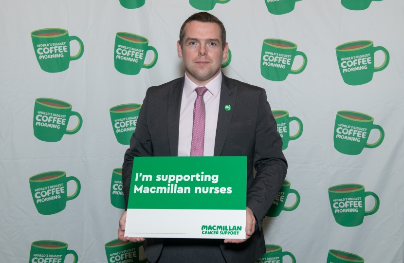 Douglas holds Macmillan Cancer charity poster