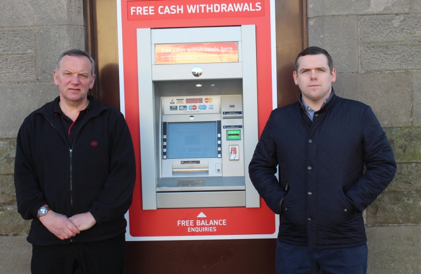 Paul and Douglas stand next to the ATM 