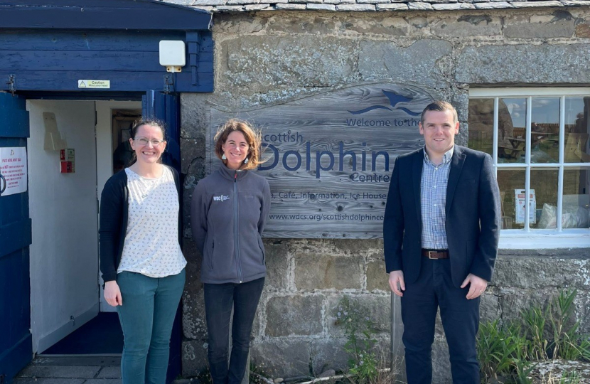Douglas stands outside the Scottish Dolphin Centre with members of staff